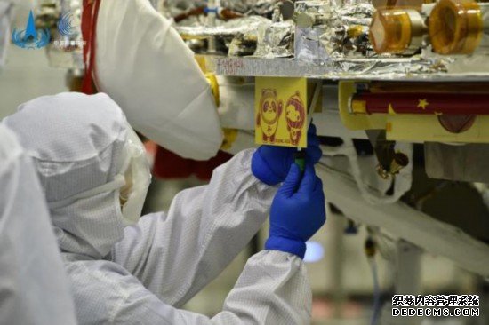 工作人员正在火星着陆器上安装吉祥物