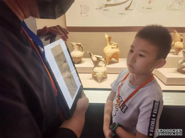 在山东博物馆，前来参观的小朋友正认真听工作人员讲解。人民网记者 杨迪摄