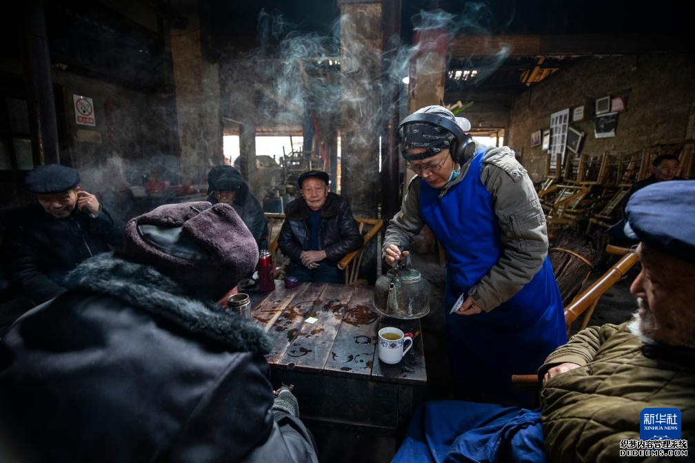 在成都市双流区彭镇观音阁老茶馆，老板李强（右二）为茶客们添水（2021年11月23日摄）。 新华社记者 沈伯韩 摄